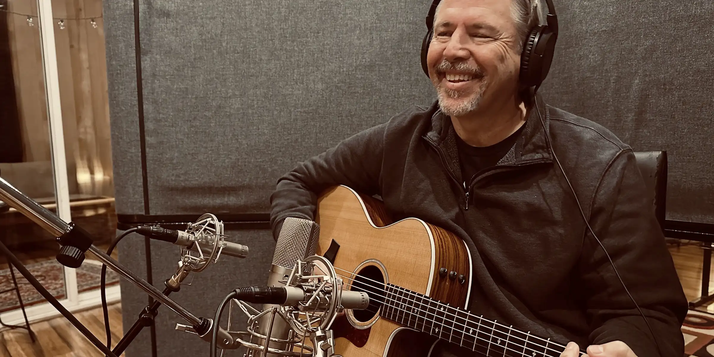 Close-up of Anthony Giaccio in the studio with an acoustic guitar.
